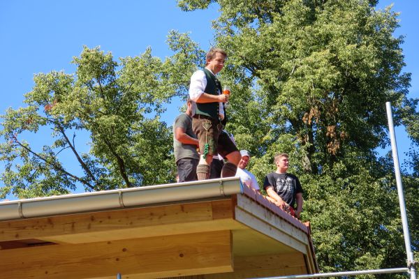 Zimmerer oder Schreiner beim Richtfest eines Holzhauses