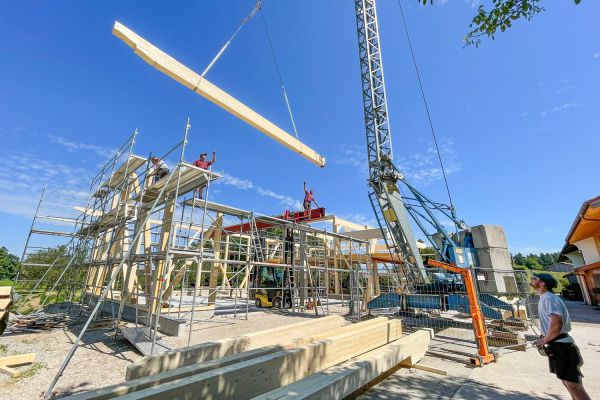 Arbeiten als Zimmerer oder Schreiner auf der Baustelle eines Holzhauses